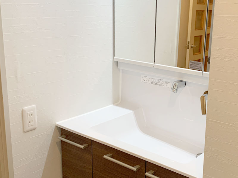 大田区の洗面リフォーム事例 使いやすい洗面台と白いクロス 床で 明るく快適な洗面所